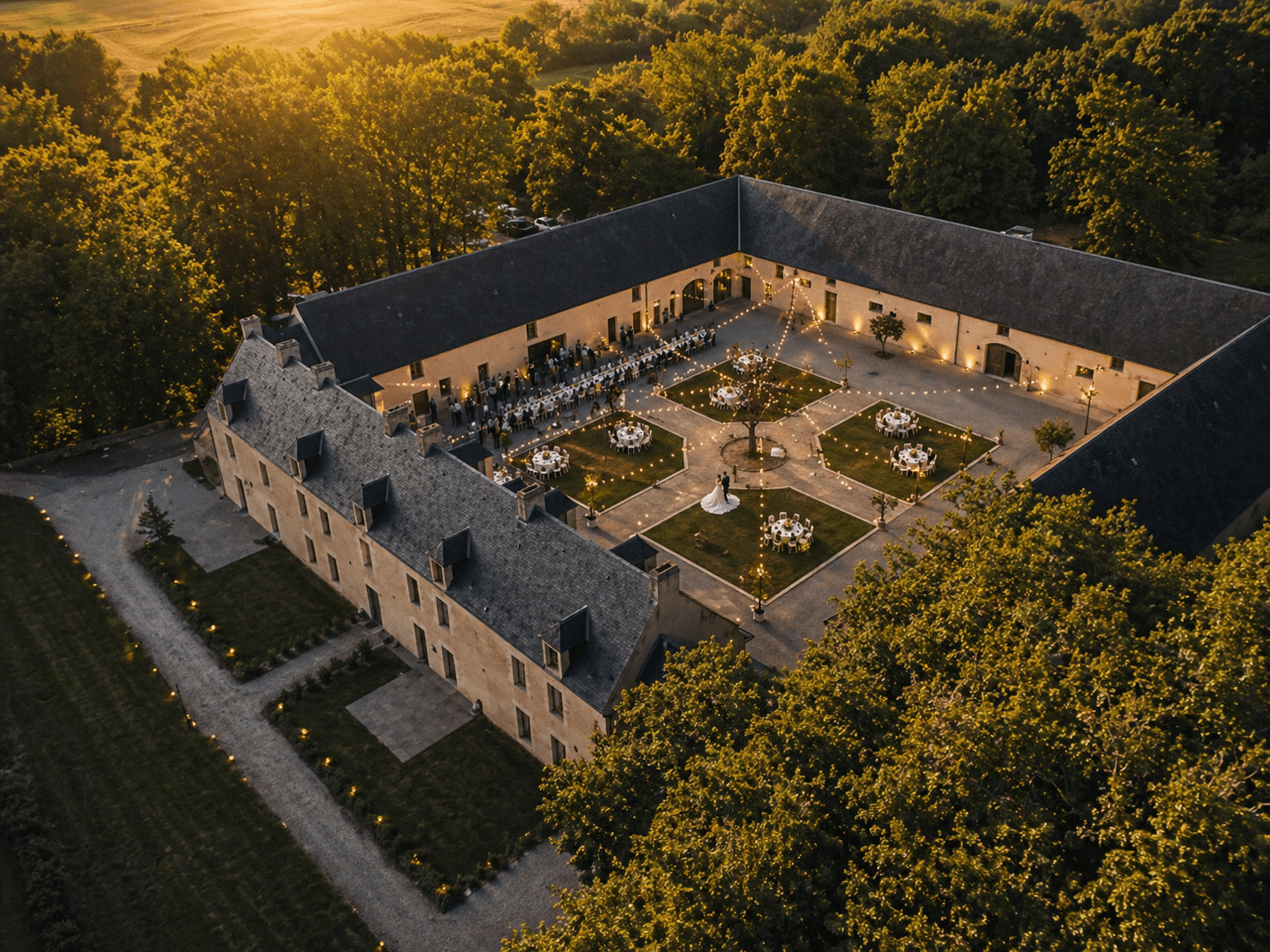 Vue aérienne du Domaine de la Cour des Lys au coucher de soleil — mariage dressé dans la Cour d'Honneur