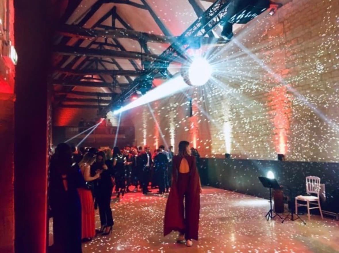 Soirée d'entreprise dans la grande salle du Domaine de la Cour des Lys — boule à facettes, jeux de lumière et piste de danse